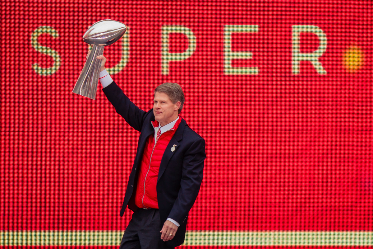 Kansas City Chiefs owner Clark Hunt hoists the Vince Lombardi Trophy above his head.