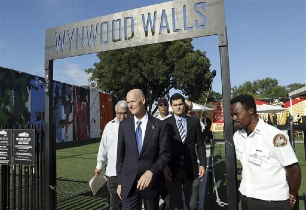 El gobernador de Florida, Rick Scott, al centro, se retira del museo de arte Wynwood Walls al término de una conferencia de prensa en el vecindario Wynwood de Miami, el lunes 19 de septiembre de 2016. El gobernador dijo que el distrito artístico ya no es considerado una zona activa de transmisión del zika. Desde hace 45 días no se ha vuelto a presentar caso alguno de zika en Wynwood.