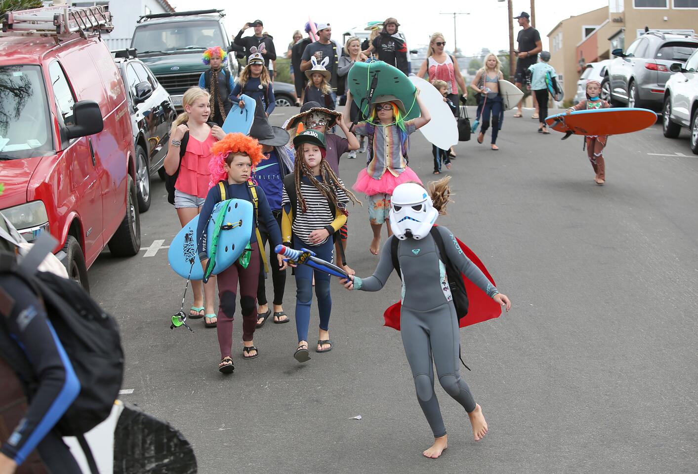 Young costumed surfers parade to Thalia Street Beach on Friday for the Laguna Beach Surf School summer program.