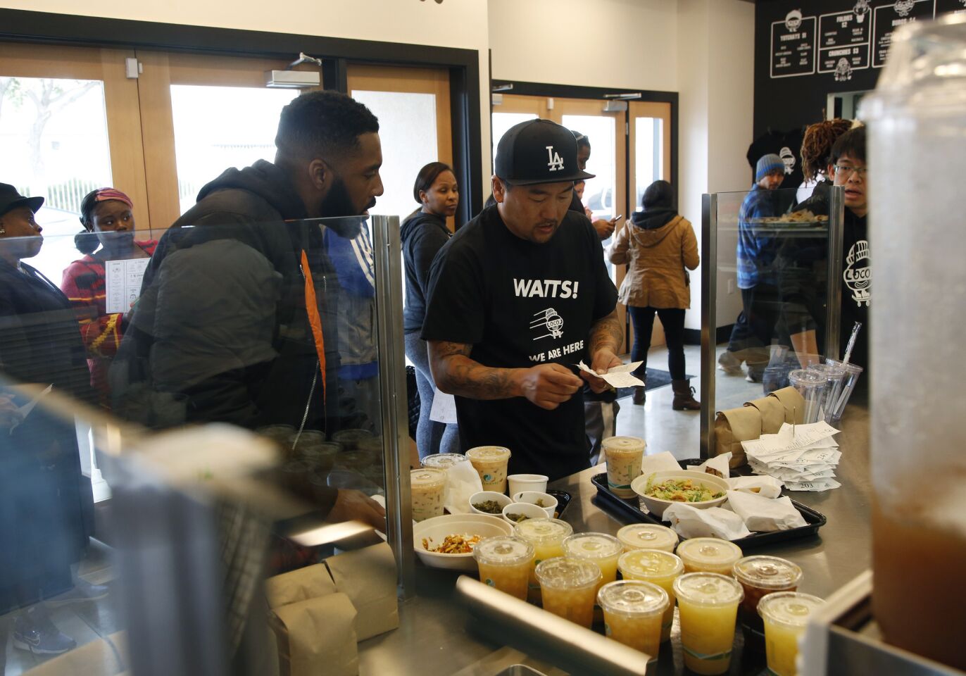 Chef Roy Choi, right, goes over an order with a diner at LocoL.