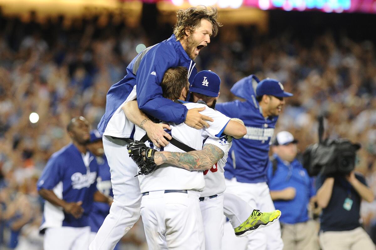 Dodgers ace Clayton Kershaw, top, celebrates with his teammates after clinching the National League West title for the second consecutive year.