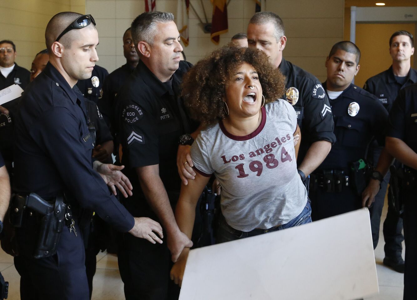 LAPD officers arrest a protester in the lobby of the police headquarters on suspicion of failure to disperse after Chief Charlie Beck gave details to the media about the shooting death of Carnell Snell Jr.