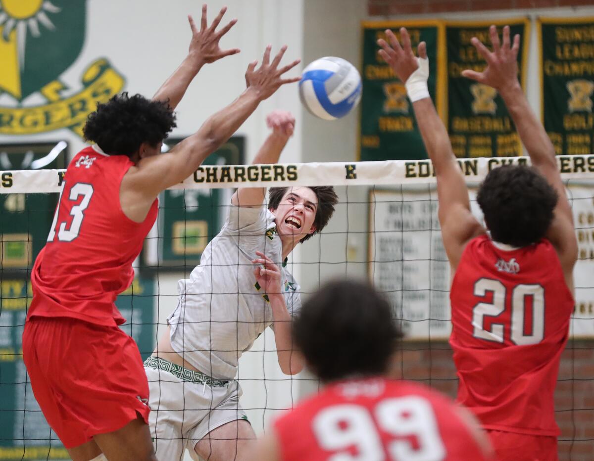 Edison's Ian Joyce (17) hammers a kill past Mater Dei blockers Jeremiah Potasi (13) and Cameron Massoudi (20).