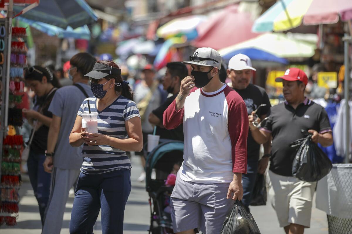 People walk in a street of shops.