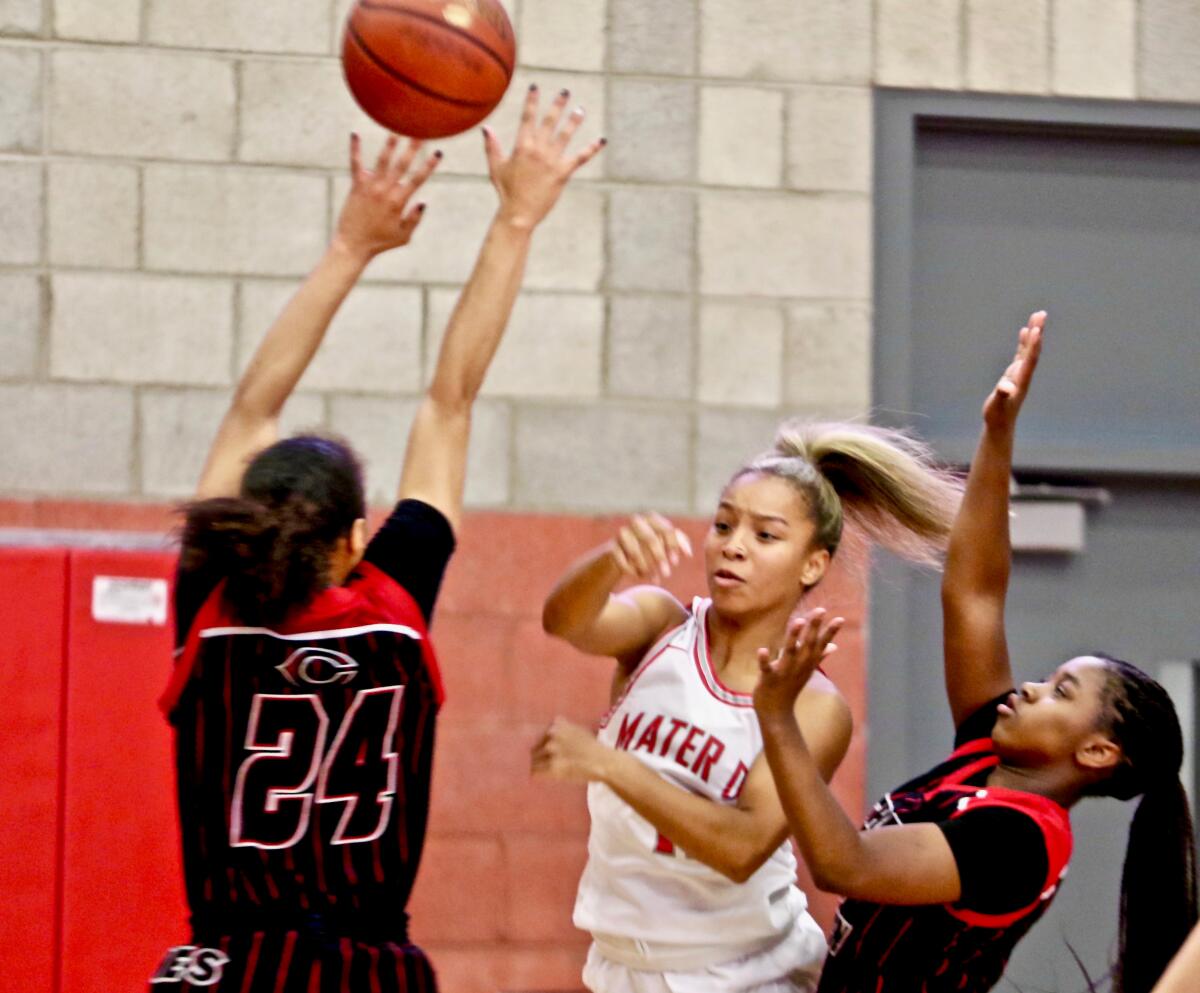 Mater Dei point guard Caia Elisaldez (center) makes a pass in the lane.