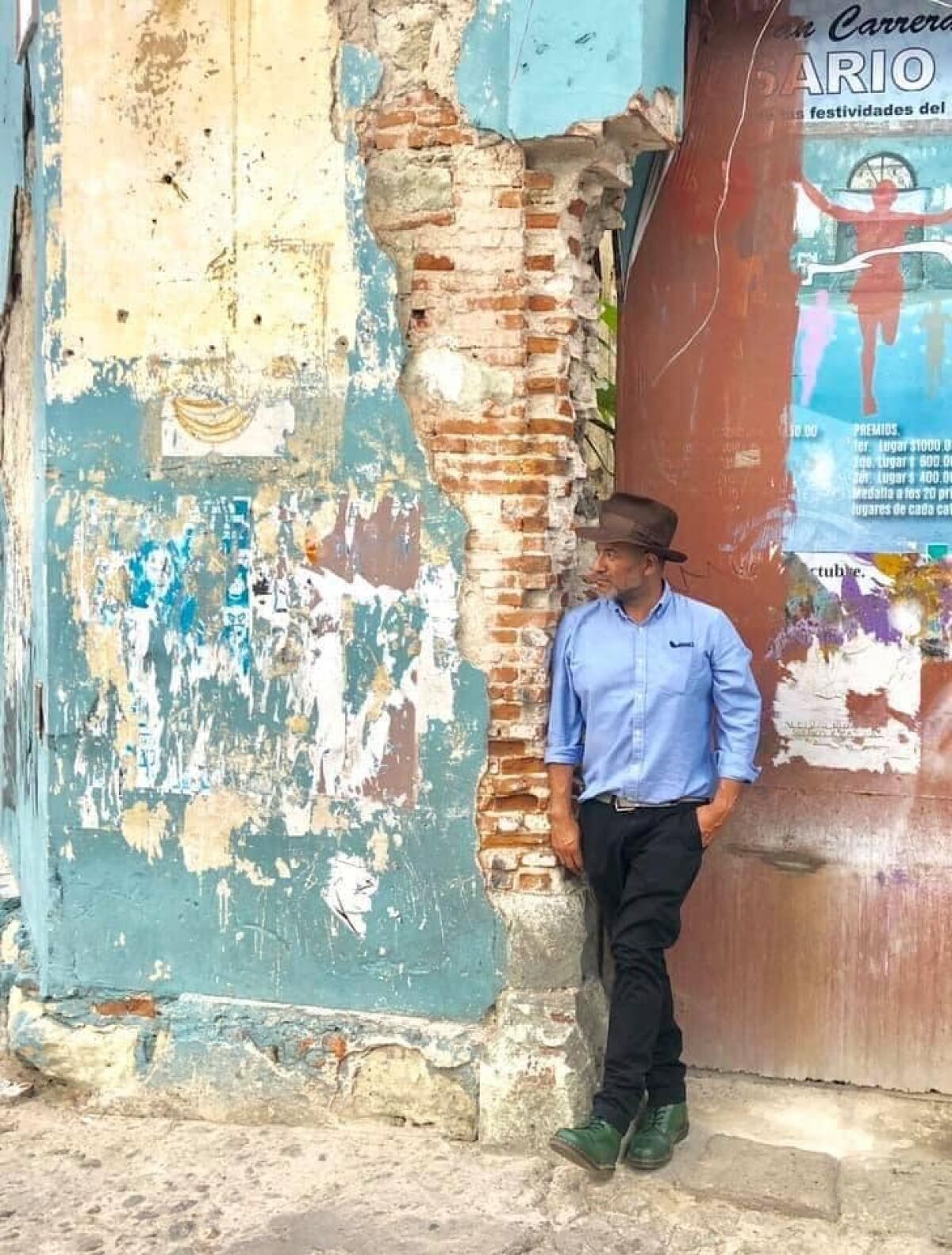 Juan Escobedo leans against a doorway.