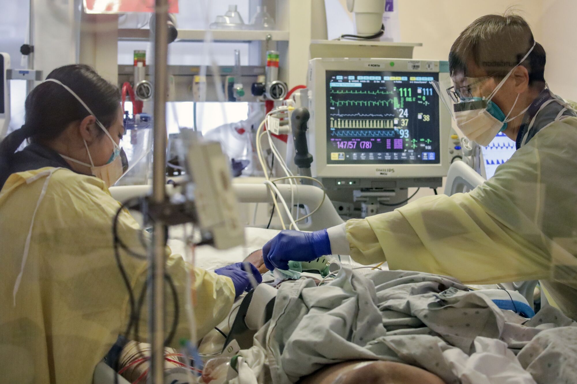 Doctors attend to a COVID patient under treatment in an intensive care unit at Arrowhead Regional Medical Center 