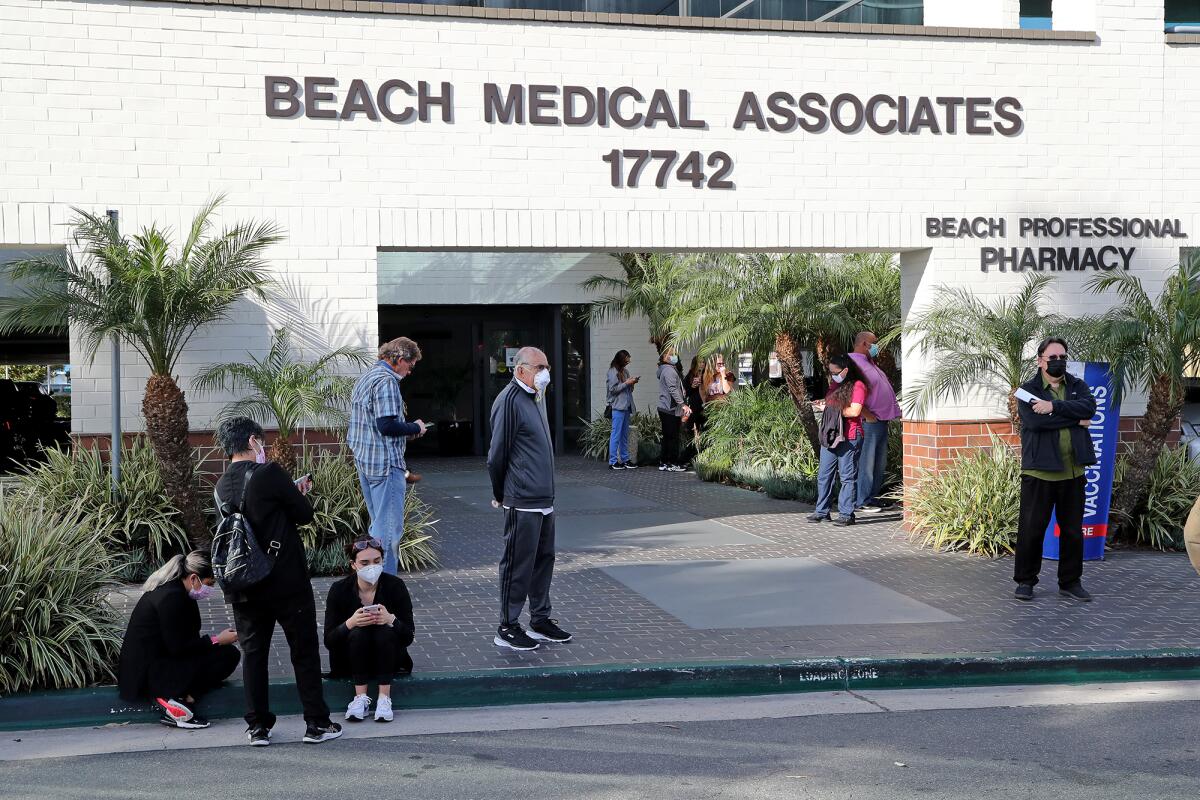 People wait outside as firefighters deal with smoke at Beach Medical Associates and Beach Professional Pharmacy on Friday.