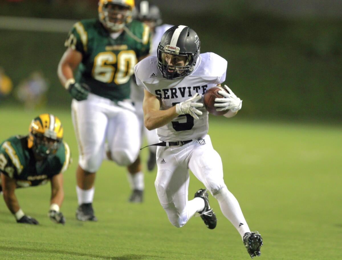 Servite running back Nick Lopiccola breaks past Edison High defenders during Anaheim's 31-14 victory on Sept. 19, 2013.