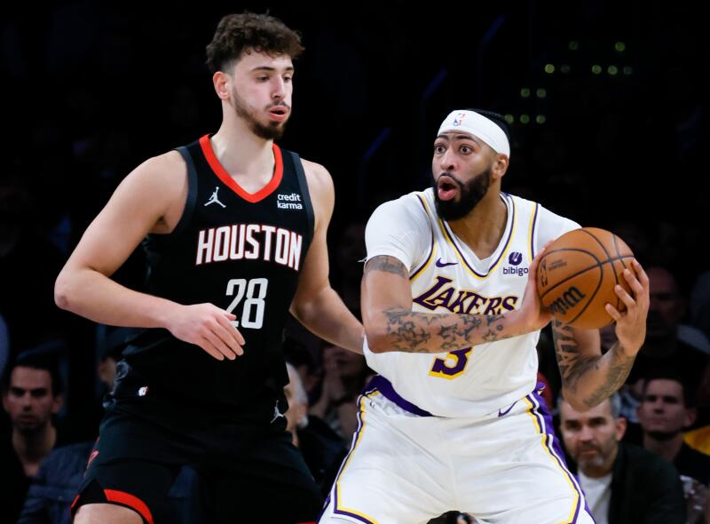 Lakers star Anthony Davis looks to pass in front of Houston Rockets center Alperen Sengun in the first half.