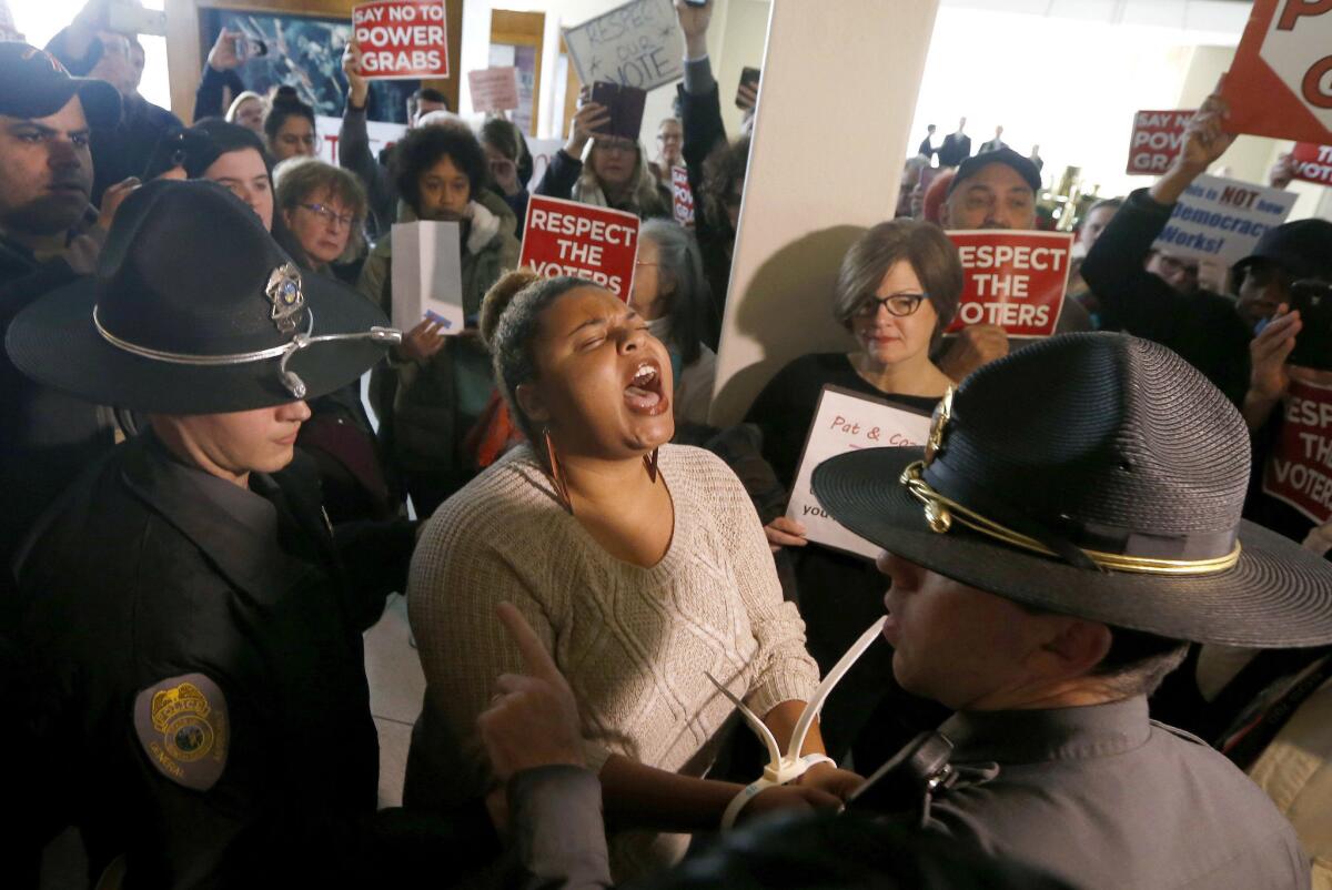 A protester shouts as she is arrested outside the House gallery during a special session of the North Carolina General Assembly in Raleigh on Friday.