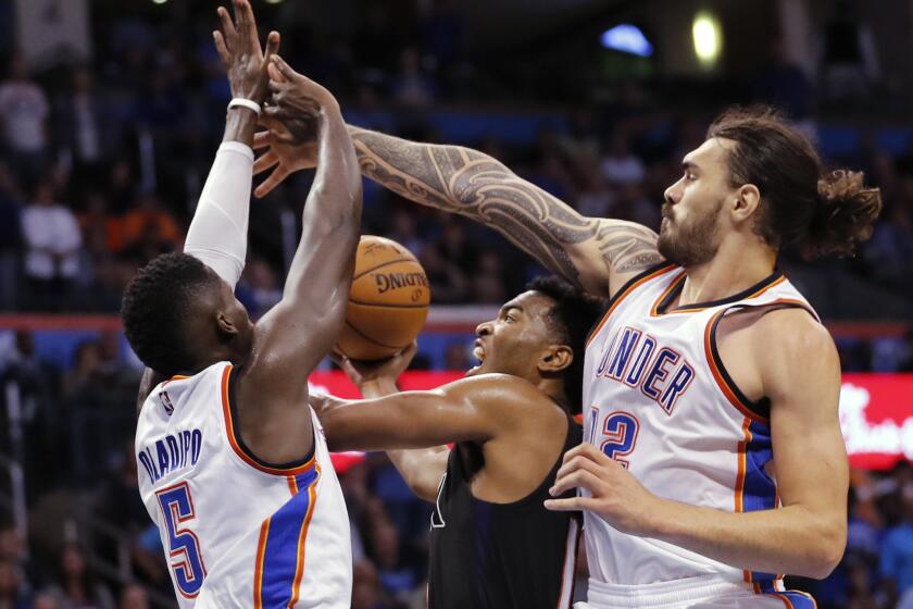 Suns forward T.J. Warren (12) is caught between Oklahoma City Thunder guard Victor Oladipo (5) and center Steven Adams (12) during the second half of a game on Oct. 28.