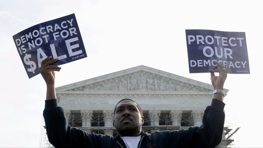 A protester takes part in a demonstration outside the Supreme Court in 2013 as the court heard arguments on campaign finance.