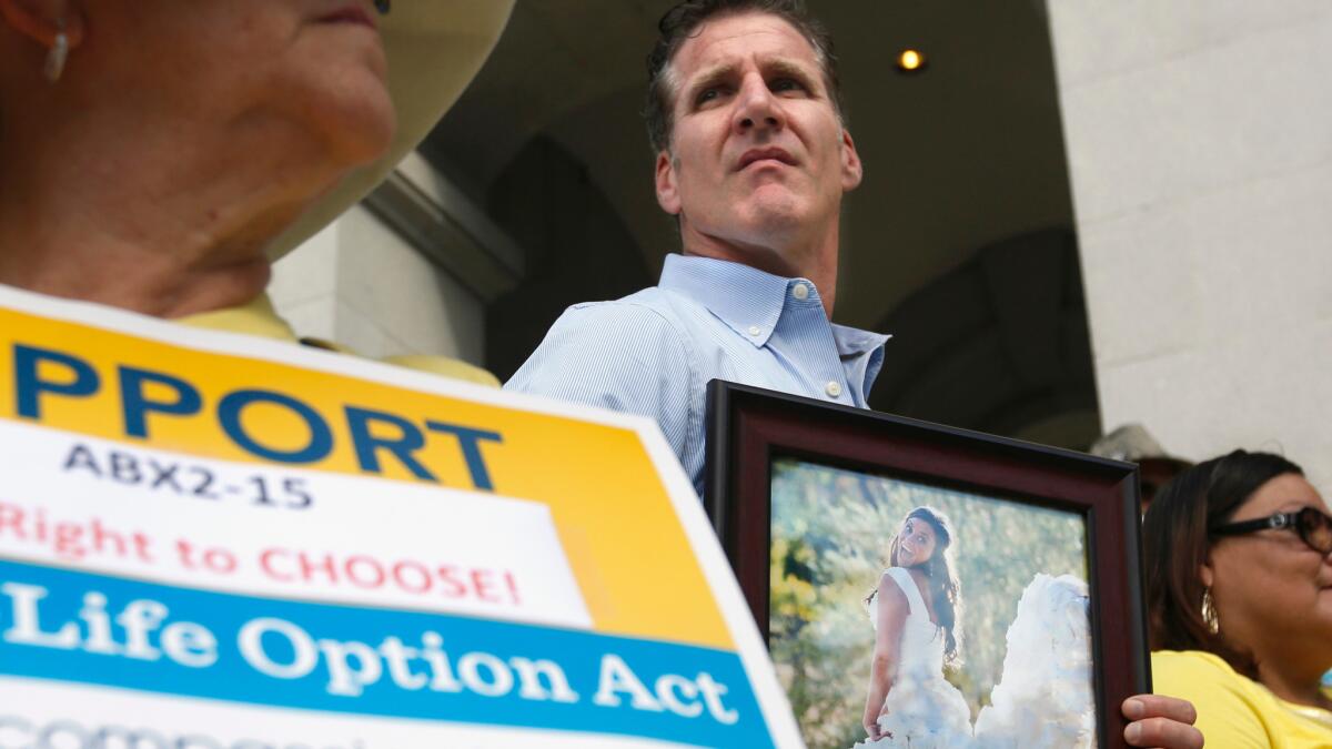 Dan Diaz holds a photo of his late wife, Brittany Maynard, during a rally in Sacramento last year calling for Gov. Jerry Brown to sign right-to-die legislation.
