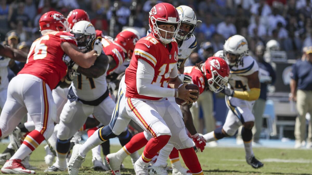 Chiefs quarterback Patrick Mahomes looks over his shoulder on an option play against the Chargers.