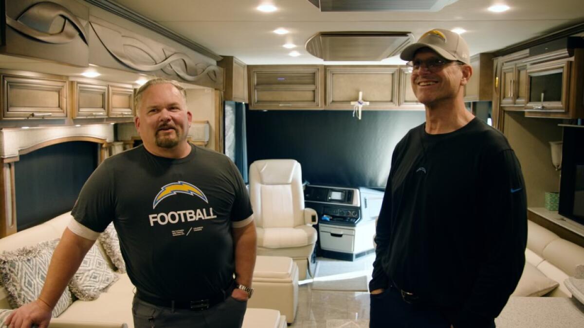 New Chargers offensive coordinator Greg Roman (left) and Jim Harbaugh check out the inside of the coach's RV on the beach.