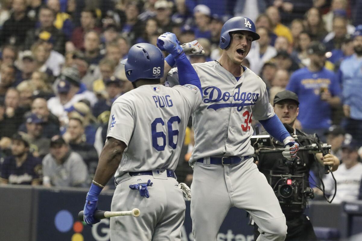 Cody Bellinger celebrates with Yasiel Puig after hitting a two-run homer in Game 7 of the 2018 NLCS.