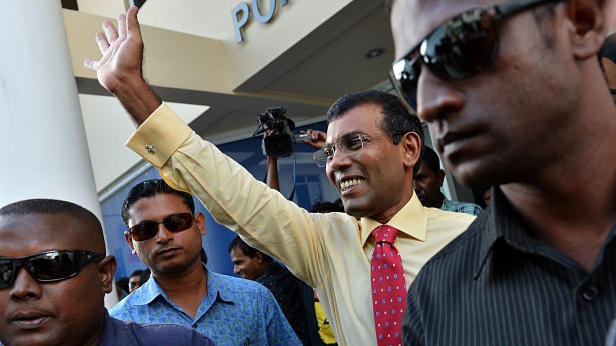In Male in 2013, Mohamed Nasheed waves to supporters outside the election office.
