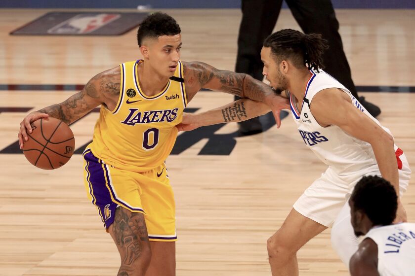 Los Angeles Lakers' Kyle Kuzma (0) is defended by Los Angeles Clippers' Amir Coffey (7) during the third quarter of an NBA basketball game Thursday, July 30, 2020, in Lake Buena Vista, Fla. (Mike Ehrmann/Pool Photo via AP)
