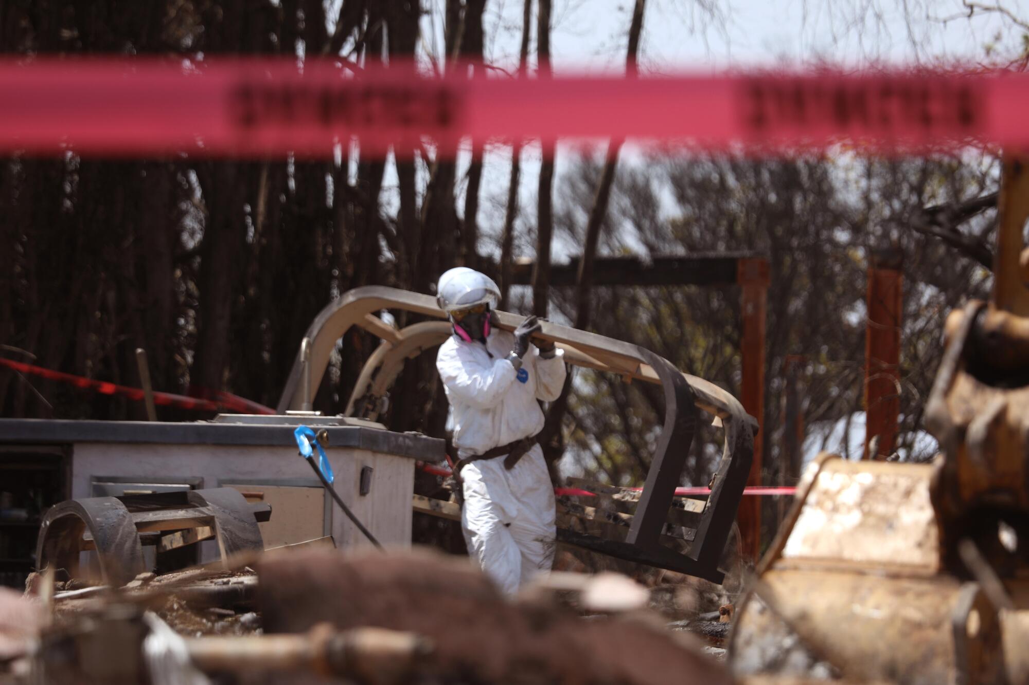 A worker clears debris from a home destroyed in the Palisades fire.