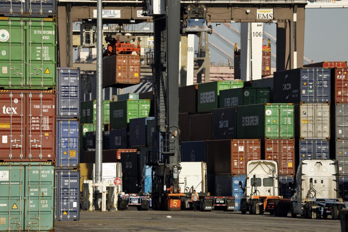 Container ships are unloaded as trucks line up to receive containers.