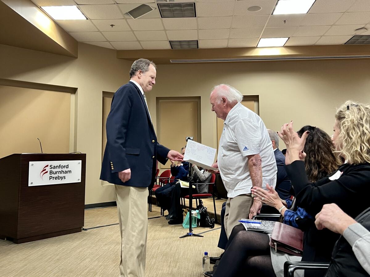 Dr. David Brenner, Sanford Burnham Prebys president and CEO (left), presents T. Denny Sanford with a thank-you card Jan. 24.