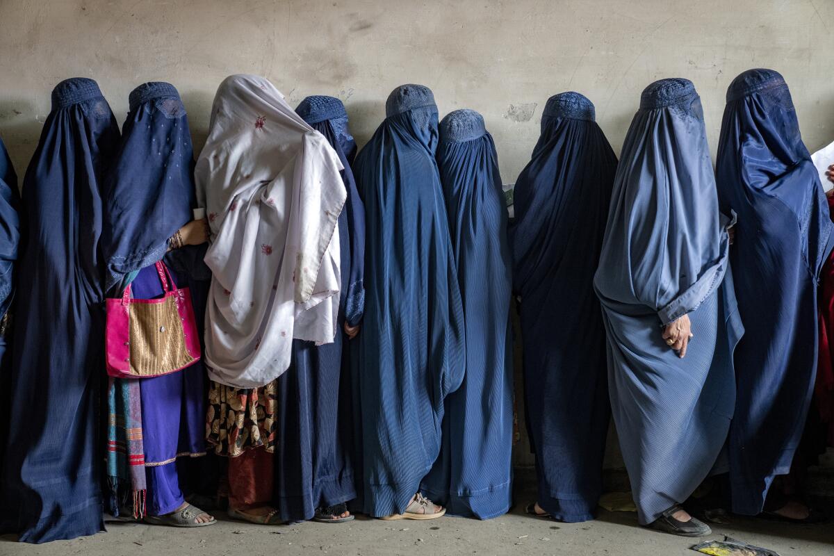 Mujeres afganas esperan para recibir raciones de comida entregadas por un grupo humanitario, 