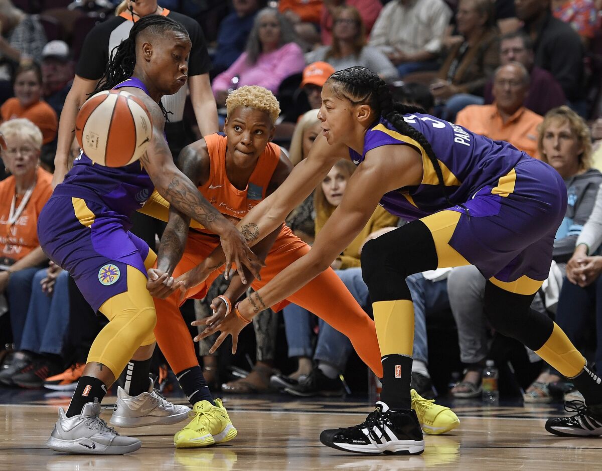 Connecticut Sun's Courtney Williams, center, passes between Sparks' Riquna Williams, left, and Candace Parker during the first half of Game 2 of a WNBA playoff game on  Thursday in Uncasville, Conn.