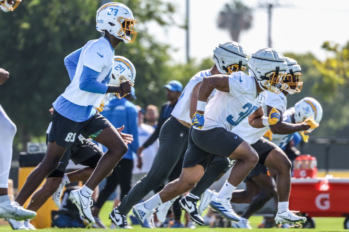 Chargers running back Austin Ekeler (30) warms up with teammates during training camp.