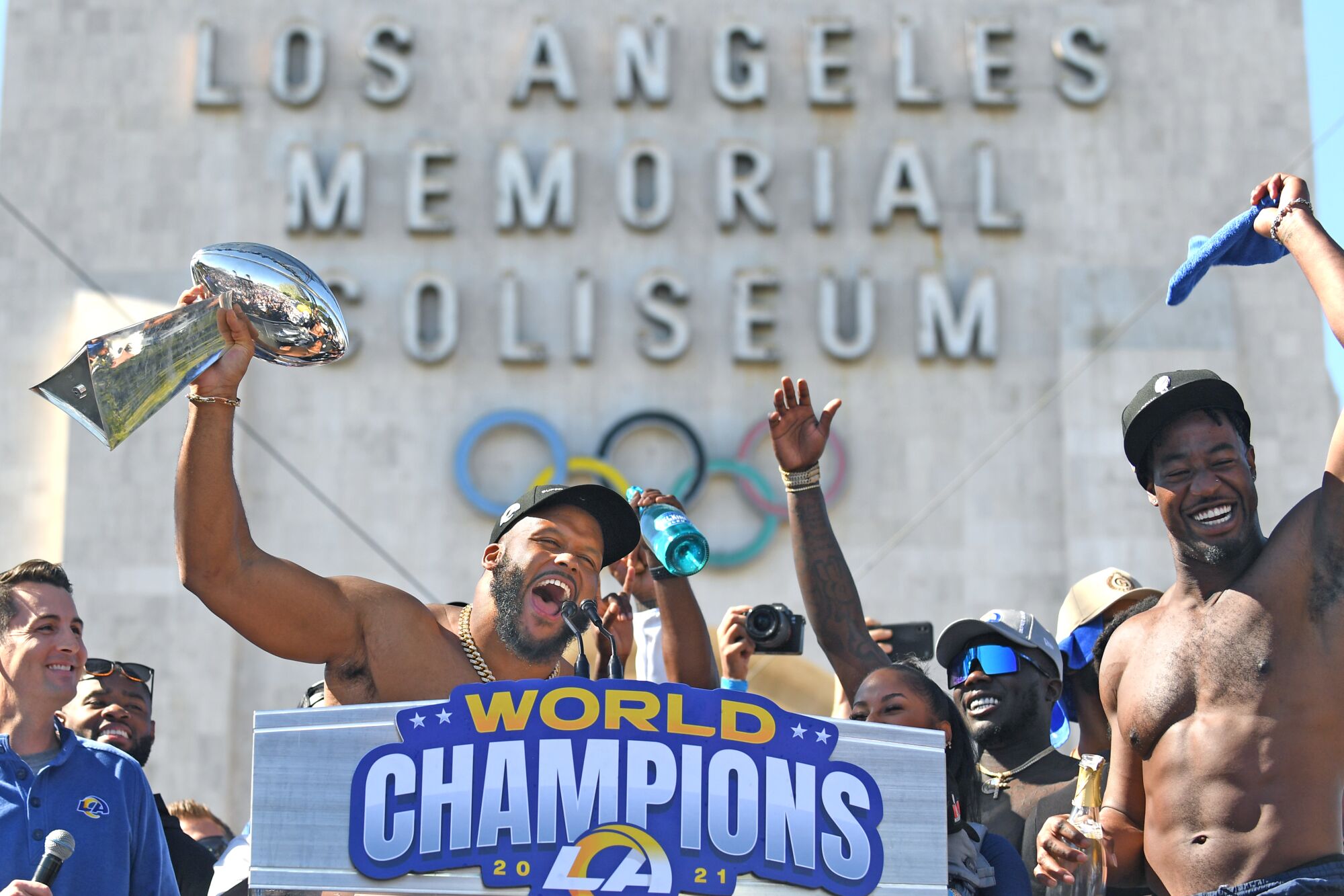 Rams defensive end Aaron Donald holds the championship trophy during a rally in front of the L.A. Coliseum.