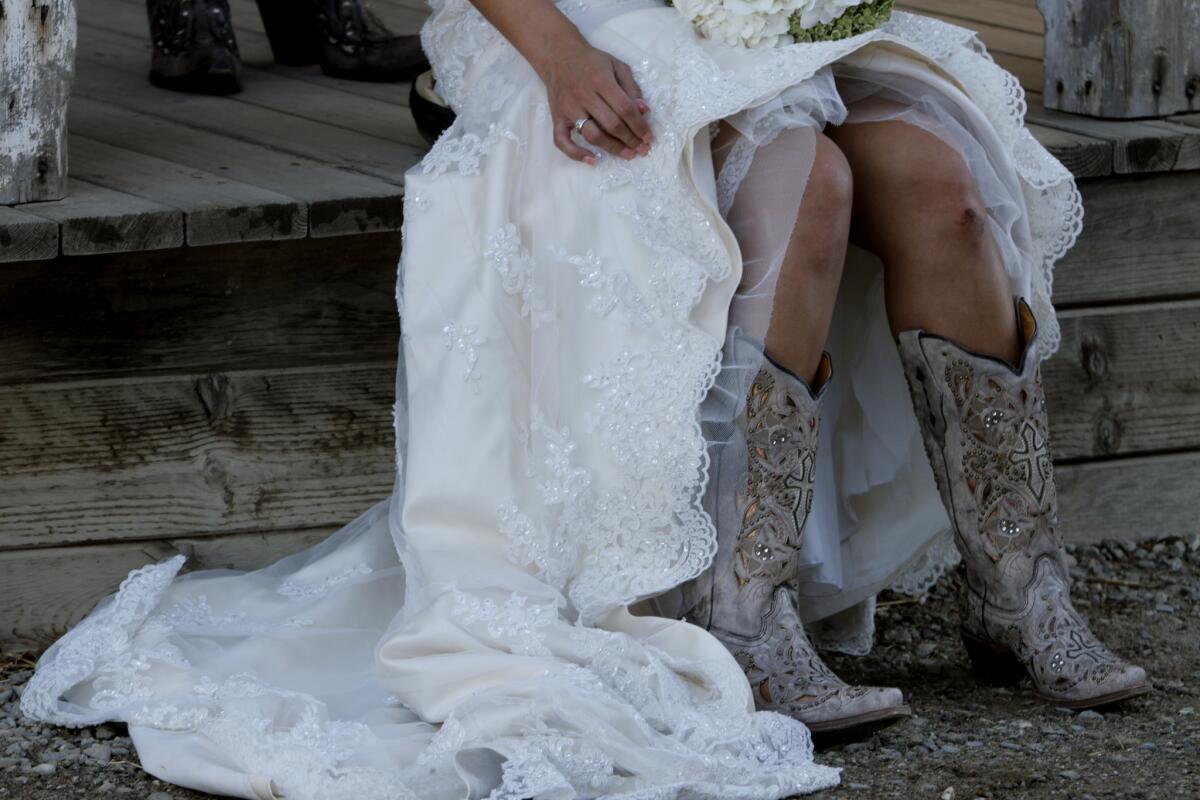 Showing off her boots, bride Anna Silva has her wedding portraits taken before her ceremony at The Double T, an organic dairy farm in Stevinson, in the Central San Joaquin Valley.