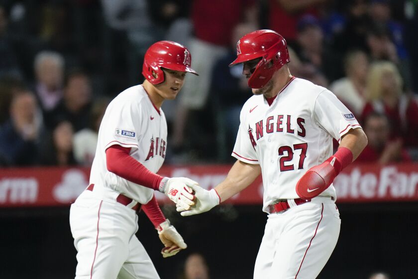 Los Angeles Angels' Shohei Ohtani, left, and Mike Trout celebrate after they scored on single by Matt Thaiss during the fifth inning of the team's baseball game against the Chicago Cubs on Tuesday, June 6, 2023, in Anaheim, Calif. (AP Photo/Jae C. Hong)