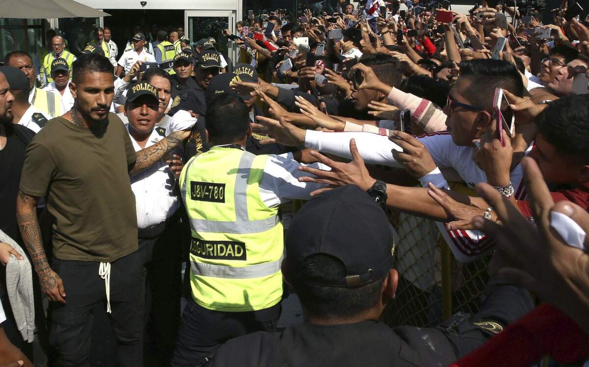El capitán de la selección de Perú Paolo Guerrero (izquierda) recibe el saludo de hinchas al llegar a Lima, Perú, el martes 15 de mayo de 2018.