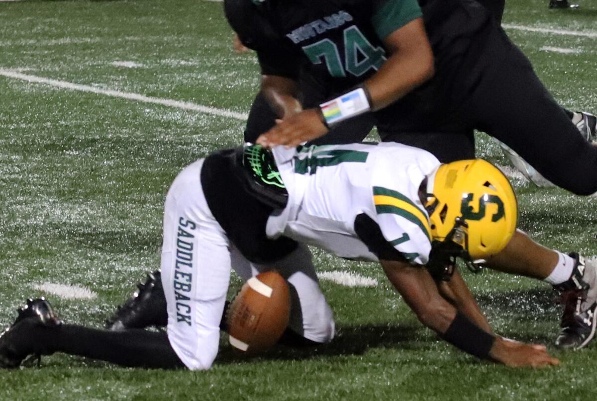 Saddleback quarterback Joey Wilson (14) fumbles following a tackle by Costa Mesa's Jafta Howerton on Friday.