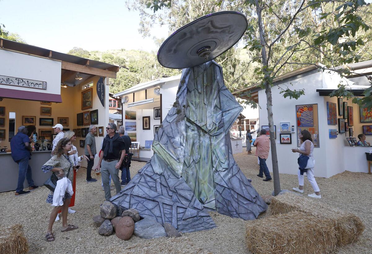 A giant flying saucer scene greets visitors at the entrance of the Sawdust Art Festival on Tuesday in Laguna Beach.