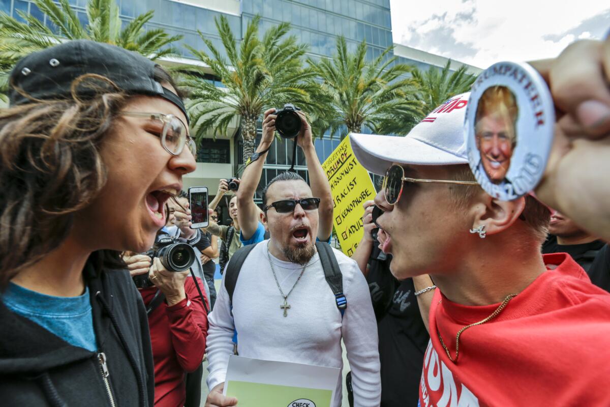 Donald Trump supporter Jake Towe, right, faces off with Trump protester Joshua Gonzalez, left, outside the Anaheim Convention Center during a Trump rally Wednesday, May 25, 2016.