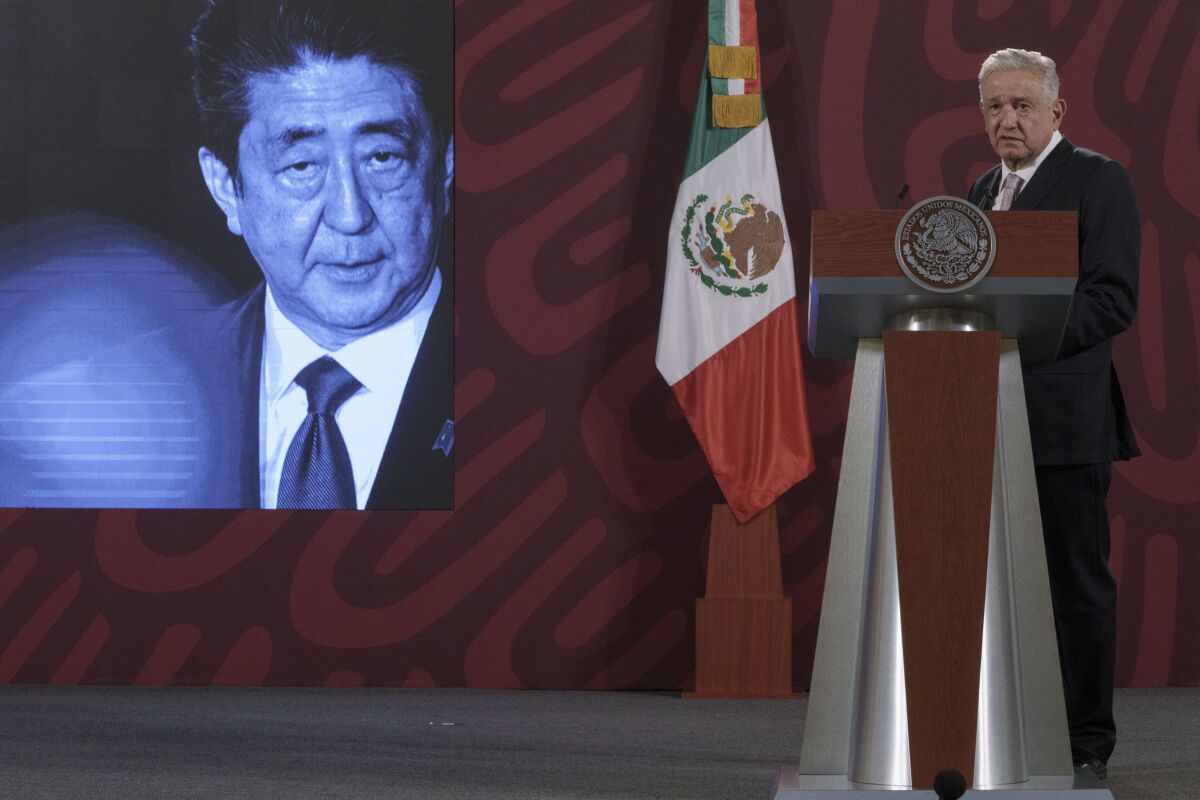 A photo of Japanese Prime Minister Shinzo Abe is displayed on the screen as Mexican President Andres Manuel Lopez Obrador offers his condolences following his death during his daily press conference at the National Palace in Mexico City, Friday, July 8, 2022. Former Prime Minister Shinzo Abe was assassinated Friday, July 8 in Japan by a gunman who opened fire on him as he delivered a campaign speech. (AP Photo/Moises Castillo)