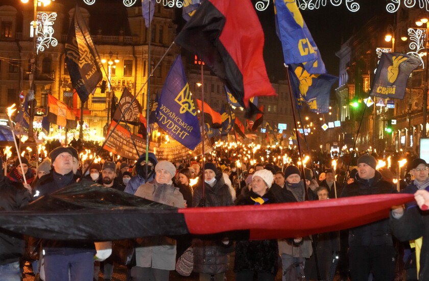 Activists of various nationalist parties carry torches during a rally in Kyiv, Ukraine, Saturday, Jan. 1, 2022. The rally was organized to mark the birth anniversary of Stepan Bandera, founder of a rebel army that fought against the Soviet regime and who was assassinated in Germany in 1959. (AP Photo/Efrem Lukatsky)