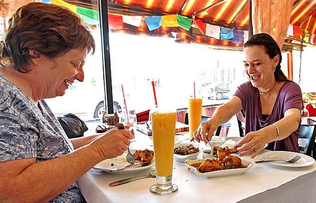 Suzy Evans of Van Nuys, left, and Marguerite Kusuhara from Redondo Beach dig in.