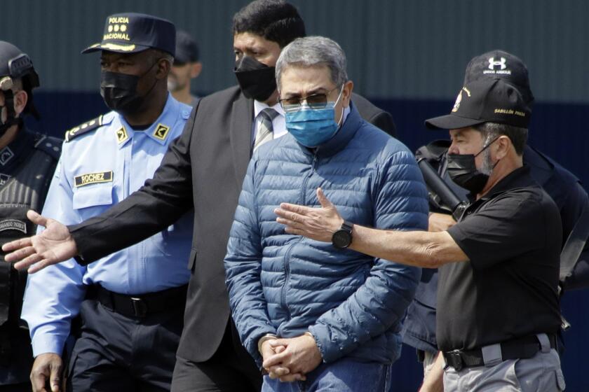FILE - Former Honduran President Juan Orlando Hernandez, second from right, is taken in handcuffs to a waiting aircraft as he is extradited to the United States, at an Air Force base in Tegucigalpa, Honduras, April 21, 2022. Hernandez was sentenced Wednesday, June 26, 2024 in New York, for his conviction on charges that he enabled drug traffickers to use his military and national police force to help get tons of cocaine into the United States. (AP Photo/Elmer Martinez, File)