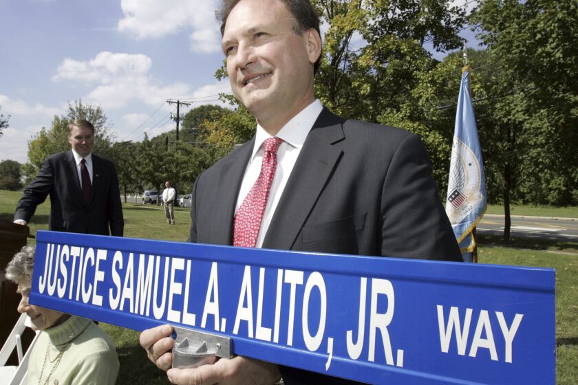 FILE - Supreme Court Justice Samuel A. Alito holds a street sign bearing his name in Hamilton, N.J., Friday, Sept.. 22, 2006. Alito, a native of Hamilton was given the sign after a street in the town was named for him. (AP Photo/Mel Evans, File)