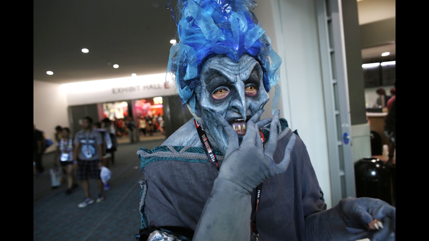 Jose Davalos Gomez, dressed as Hades from the Disney version of "Hercules", pops false teeth into his mouth before heading back into the exhibit hall.
