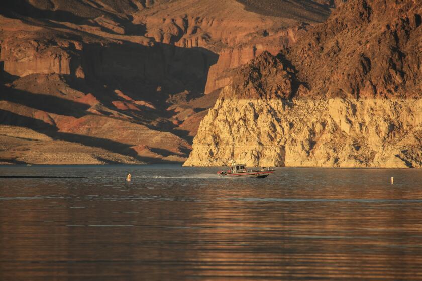 Lake Mead, NV - June 29: A law enforcement boat patrols amid signs of the drought's effect on Lake Mead. Lake Mead is at its lowest level in history since it was filled 85 years ago. The ongoing drought has made a severe impact on Lake Mead and a milestone in the Colorado River's crisis. High temperatures, increased contractual demands for water and diminishing supply are shrinking the flow into Lake Mead. Lake Mead is the largest reservoir in the U.S., stretching 112 miles long, a shoreline of 759 miles, a total capacity of 28,255,000 acre-feet, and a maximum depth of 532 feet. (Allen J. Schaben / Los Angeles Times)