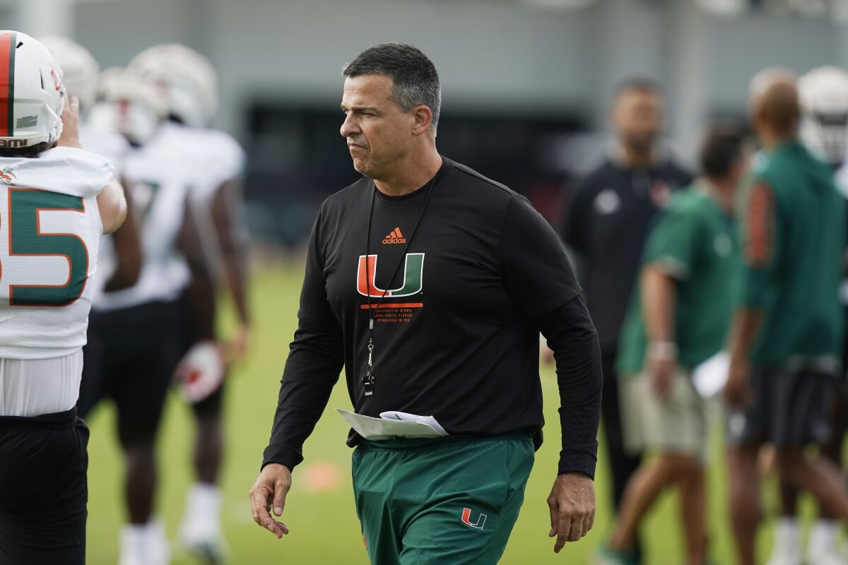 Miami head coach Mario Cristobal supervises the warm up period at the team's NCAA college football facility, Friday, Aug. 5, 2022, in Coral Gables, Fla. (AP Photo/Marta Lavandier)