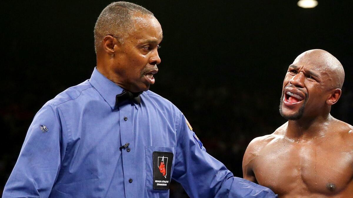 Referee Kenny Bayless hears from Floyd Mayweather Jr. during a fight against Marcos Maidana on Sept. 13, 2014.