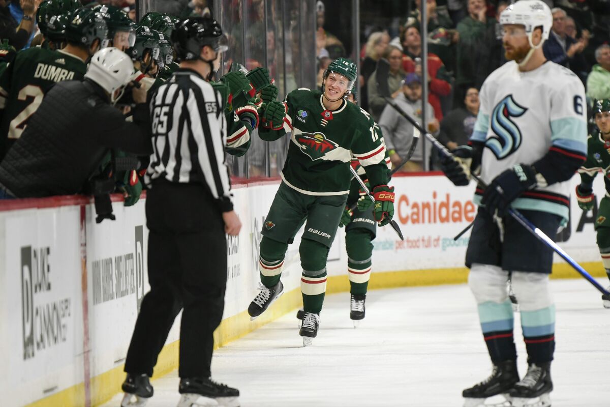 Minnesota Wild left wing Matt Boldy, center, celebrates with the bench after scoring against the Seattle Kraken during the second period of an NHL hockey game Monday, March 27, 2023, in St. Paul, Minn. (AP Photo/Craig Lassig)
