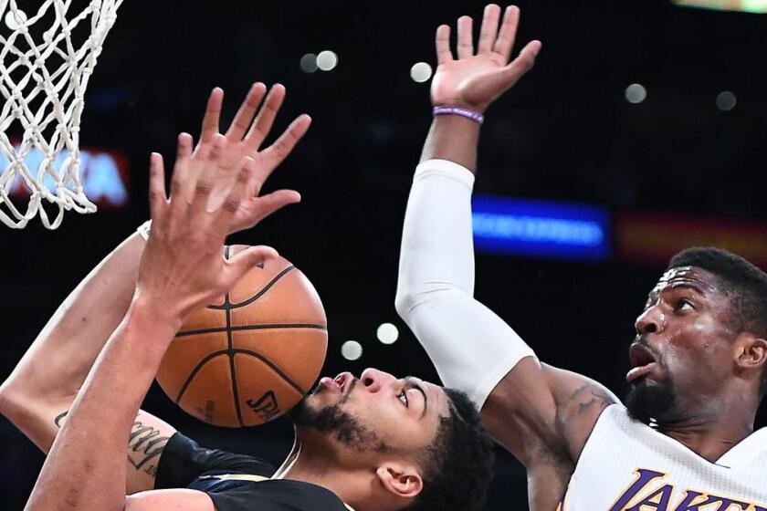 New Orleans Pelicans' Anthony Davis, left, grabs a rebound in front of Lakers' David Nwaba in the fourth quarter Sunday at Staples Center.