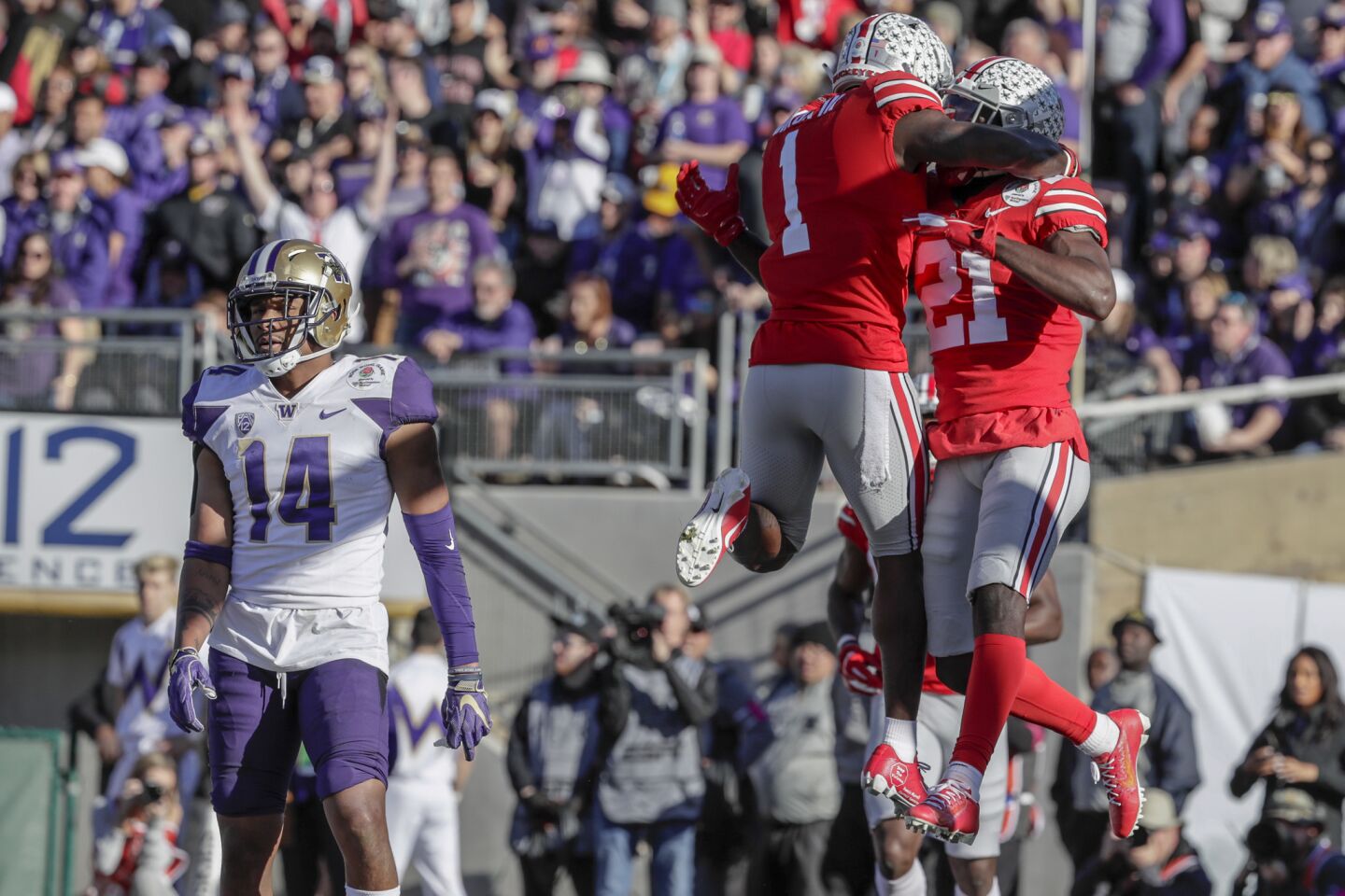 Ohio State receiver Parris Campbell, right, celebrates with treammate Johnnie Dixon after catching a touchdoen as Washington defensive back JoJo McIntosh looks on in the first quarter of the Rose Bowl.