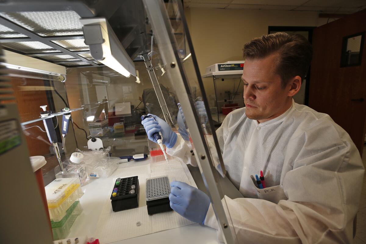 Brian Bowland, a senior clinical lab specialist in microbiology for UCLA Health, preps a mix for testing of the COVID-19 coronavirus. 