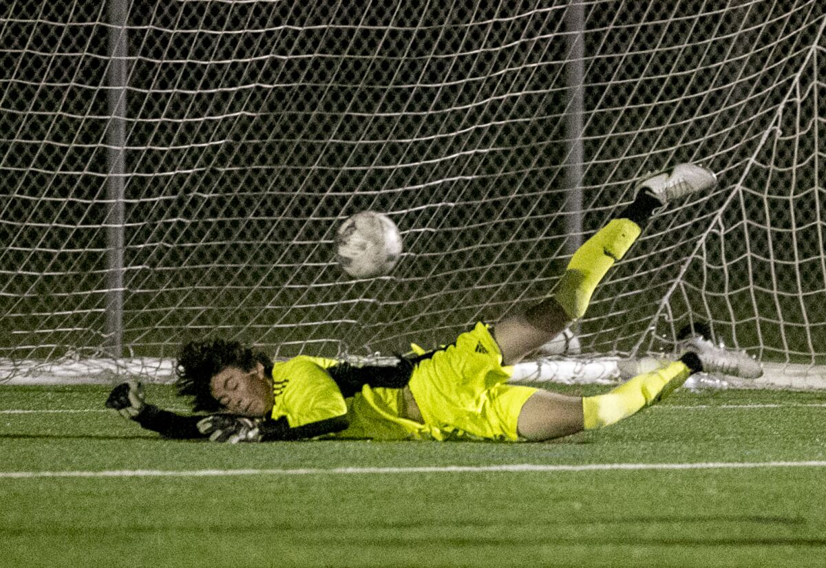 Edison's Dylan Dwight makes a game changing save during a Surf League boys' soccer match against Corona del Mar.